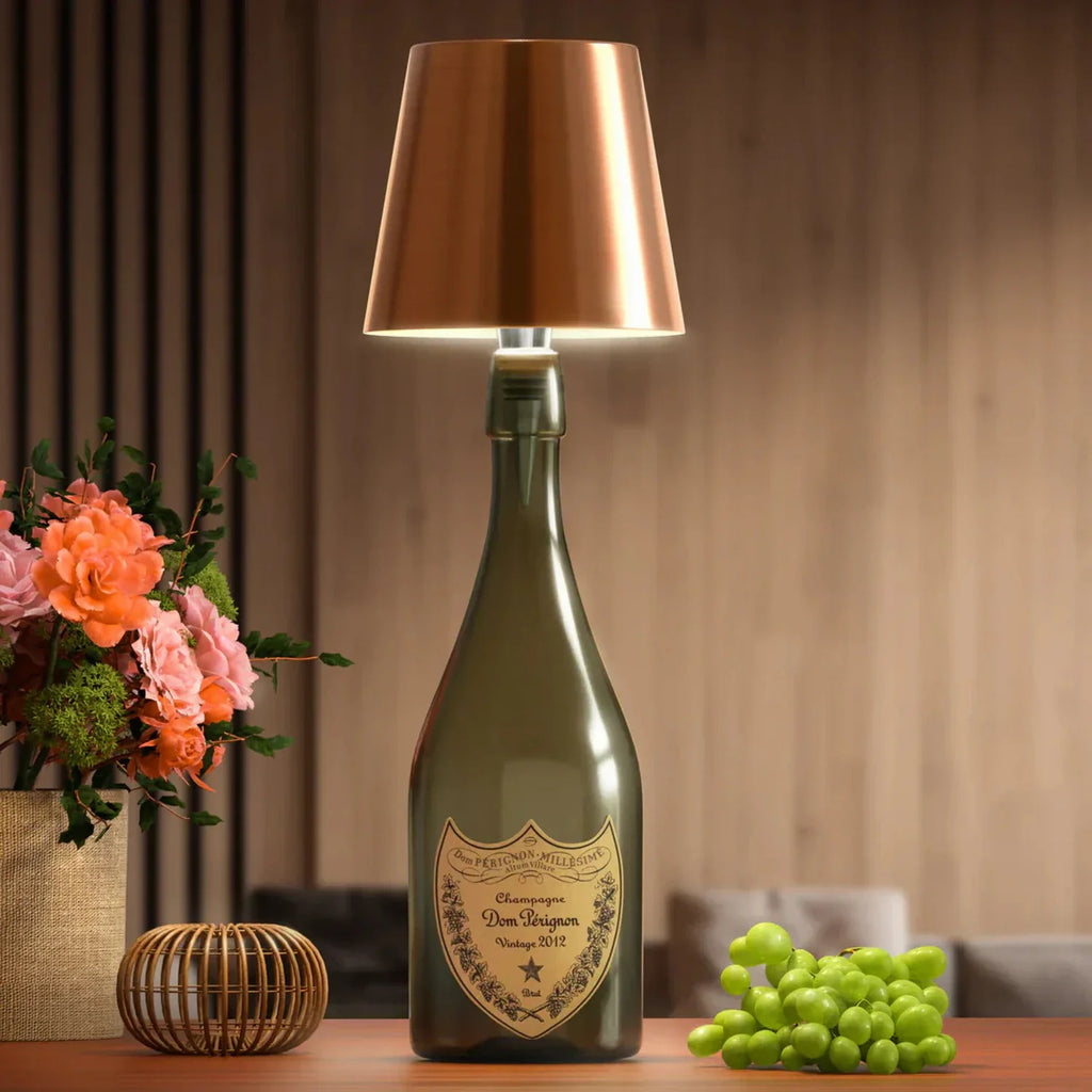 Luminária LED dourada rosé encaixada em garrafa em composição decorativa