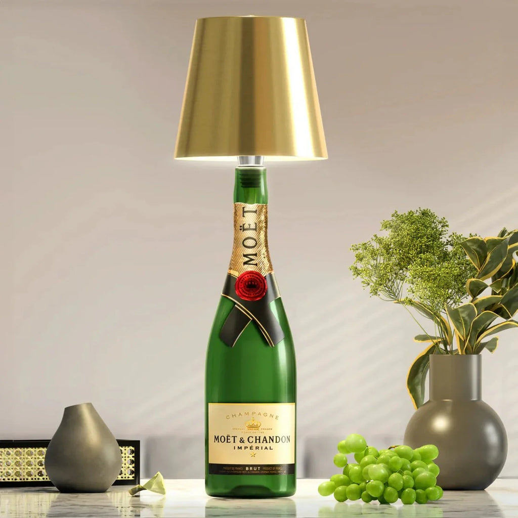 Luminária LED dourada encaixada em garrafa em composição decorativa