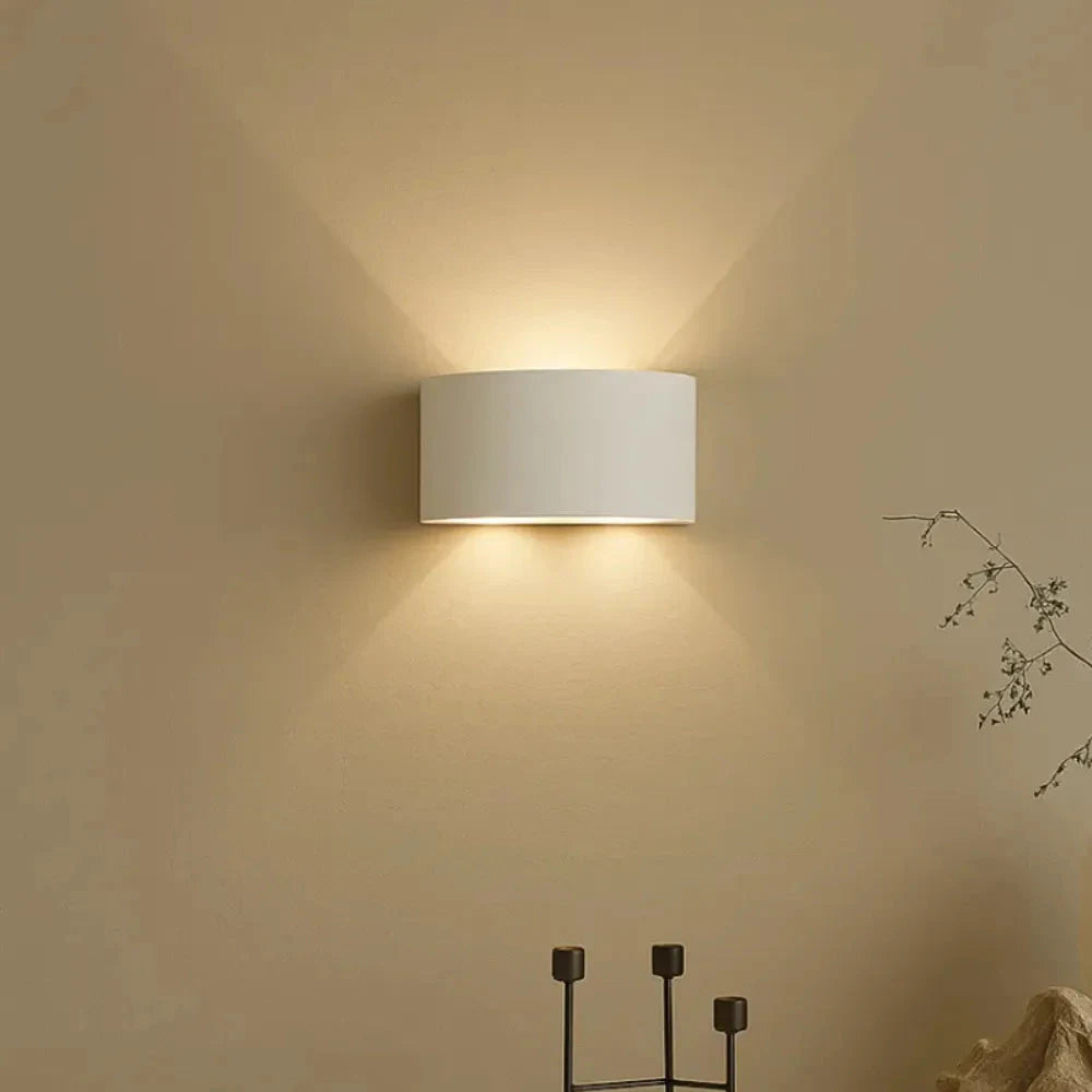 Arandela LED DuoLume branca acesa em parede bege