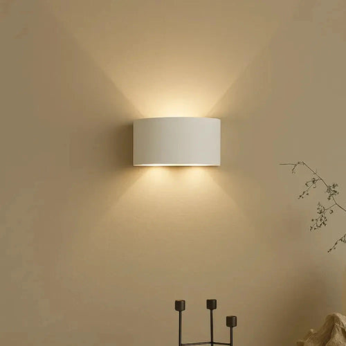 Arandela LED DuoLume branca acesa em parede bege