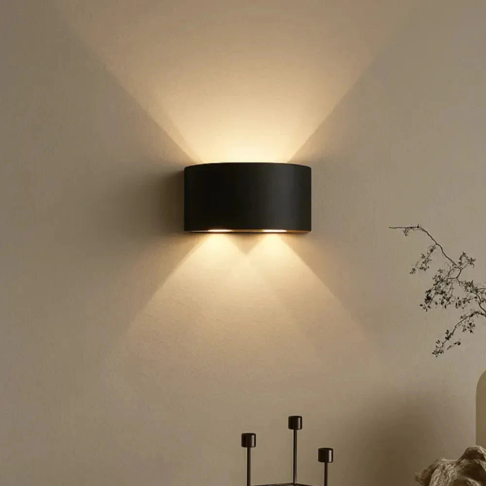 Arandela LED DuoLume preta acesa em parede bege