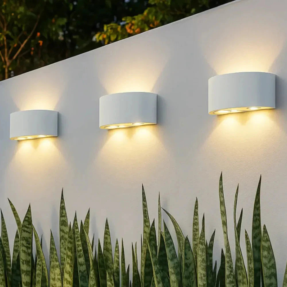 Três arandelas DuoLume brancas iluminando área externa coberta